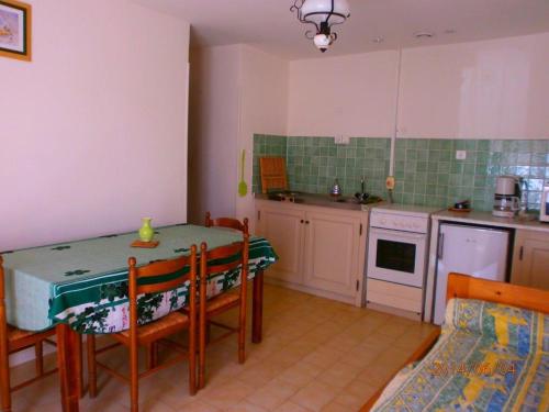 - une cuisine avec une table, une table et des chaises dans l'établissement Les gites de lozari, à Belgodère