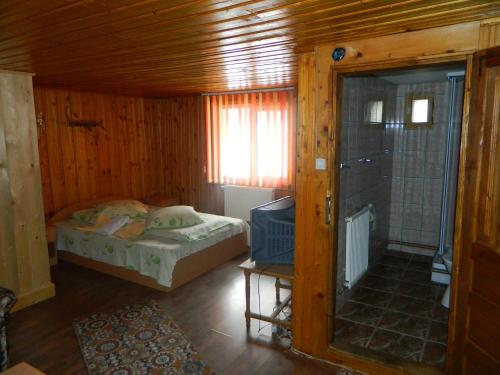 A bed or beds in a room at Pensiunea Buzdugan
