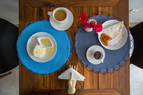 a table with two plates of food and a cup of coffee at Pousada Renda do Mar in Morro de São Paulo