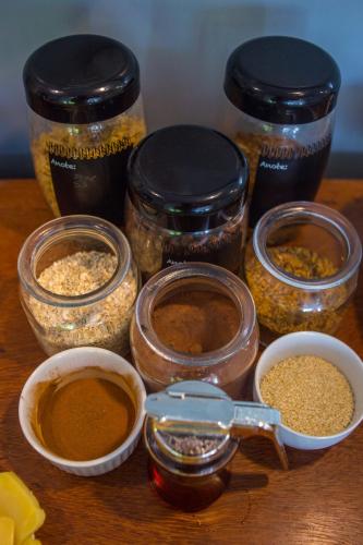 a wooden table with jars of food and spices at Pousada Renda do Mar in Morro de São Paulo