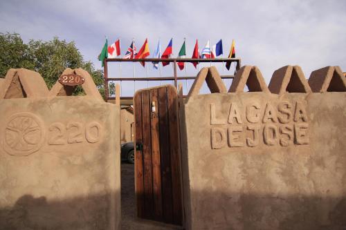 a sign for laaza deuce with flags in the background at La Casa de José in San Pedro de Atacama