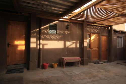 a patio with a table in the shade of a building at La Casa de José in San Pedro de Atacama