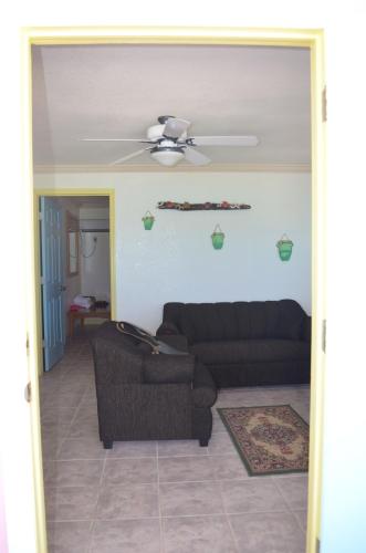 a living room with a couch and a ceiling fan at Graham's Place in Guanaja
