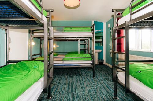YHA Malham في مالهام: سريرين بطابقين في غرفة مع أسرة خضراء