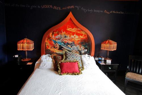a bed with a painting on the side of it at McMenamins Crystal Hotel in Portland
