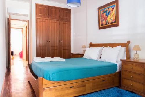 um quarto com uma cama grande e um colchão azul em Apartamento Tavira em Tavira