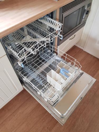 an empty dish rack in a dishwasher in a kitchen at vakantiehuis in zeeland in Sint Annaland