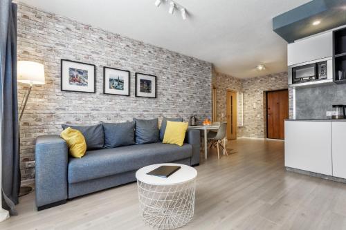 a living room with a blue couch and a brick wall at Minsk Apartment in Minsk