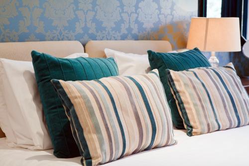 a bunch of pillows sitting on a bed at Harrogate Boutique Apartments - Self Contained Apartments in Harrogate