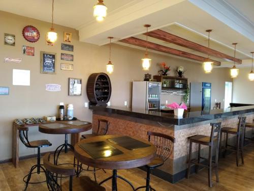 a bar in a restaurant with tables and chairs at Fazenda Morro Pelado in Águas de Lindóia