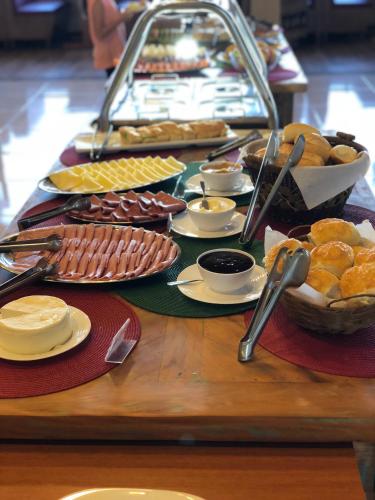 a table topped with different types of bread and pastries at Fazenda Morro Pelado in Águas de Lindóia