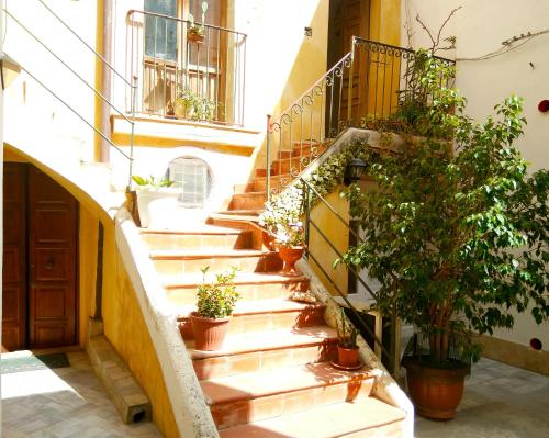 a staircase in a building with potted plants at Siracusa Ortigia by Duomo in Siracusa