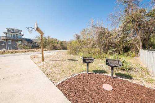 a basketball hoop and two benches in a yard at Follow the Sun in Duck