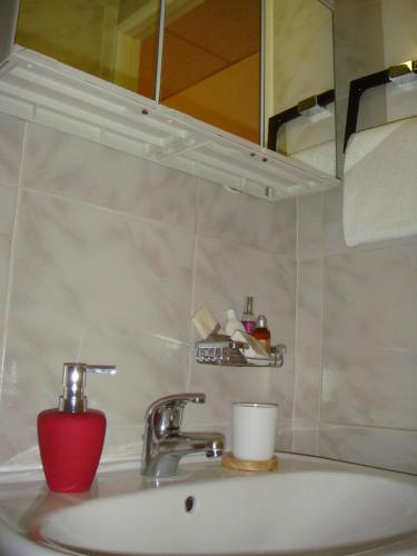 - un lavabo avec une tasse rouge et un miroir dans l'établissement Little Palace, à Cannes