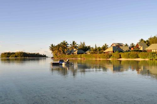 a boat on a river with houses in the background at Sokala Villas in Muri