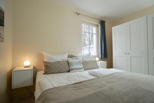 a bedroom with a large white bed with a window at Ferienappartement-Moenchgut-14 in Ostseebad Sellin