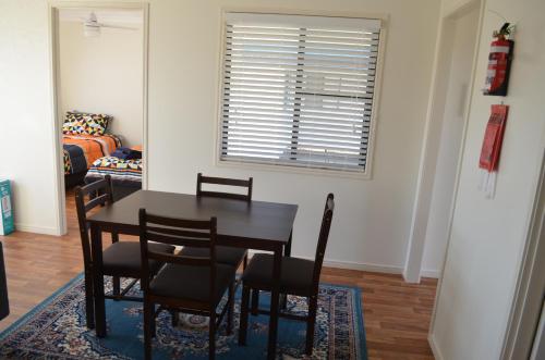 a living room with a table and chairs at Wondai Accommodation Units And Villas in Wondai