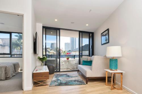 a living room with a bed and a couch at Ruby Gold Coast by CLLIX in Gold Coast