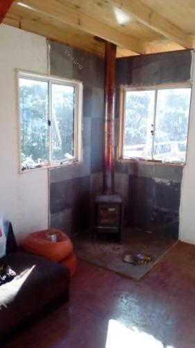 sala de estar con fogones y 2 ventanas en Cabaña en Canelo Cajón del Maipo, en San José de Maipo