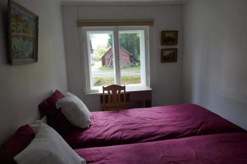 1 dormitorio con cama morada y ventana en Kärdla Holiday House, en Kärdla