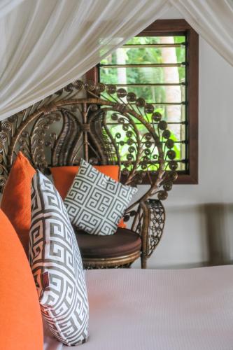 a bed with pillows on it with a window at Erakor Island Resort & Spa in Port Vila