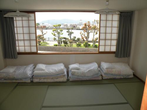 a room with a window with a row of pillows at Business Hotel Minshuku Minato in Tokushima