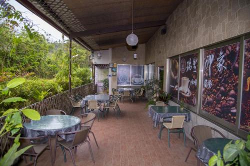 a restaurant with tables and chairs in a room at Rui Li Yinxiang Qu Homestay in Meishan