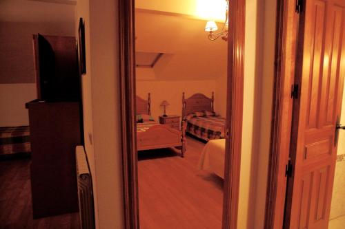 une porte menant à une chambre avec un lit et une télévision dans l'établissement Apartamentos Turisticos Casa Pastor, à Riaza