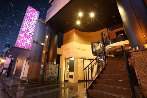 a building with a purple sign on the side of it at HOTEL le bordeaux -ル ボルドー- in Kurume
