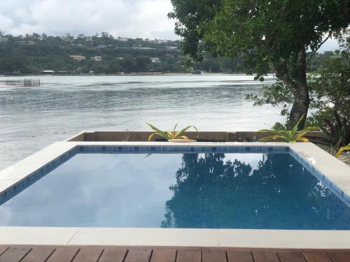 a swimming pool next to a body of water at Erakor Island Resort & Spa in Port Vila