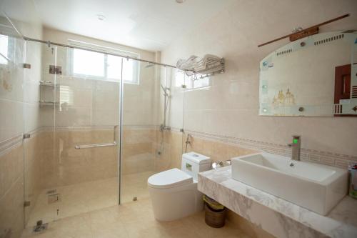 een badkamer met een douche, een toilet en een wastafel bij Biệt thự Sao Biển - SB118 FLC Sầm Sơn Resort in Sầm Sơn