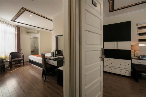a room with a bed and a desk and a door at Serenity Diamond Hotel in Hanoi