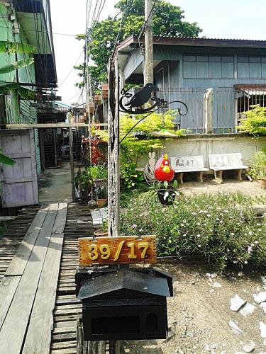 a sign in front of a building with a house at Ray Nu Guest House in Phra Nakhon Si Ayutthaya