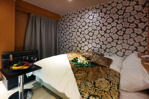 a bedroom with a bed and a table with a tray of fruit at HOTEL le bordeaux -ル ボルドー- in Kurume