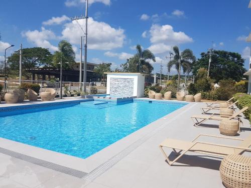 a swimming pool with lounge chairs and a swimming pool at Microtel by Wyndham South Forbes near Nuvali in Santa Rosa