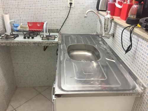 a metal sink in a kitchen with a stove at Coração de Copacabana in Rio de Janeiro