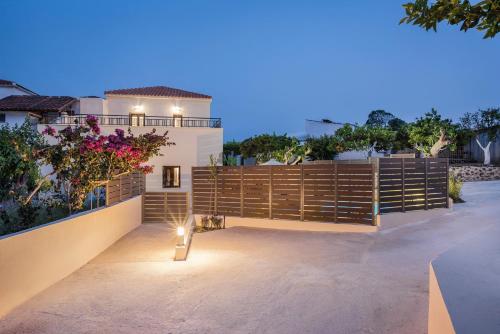 a backyard with a wooden fence and flowers at Spilia Village Hotel & Villas in Spiliá