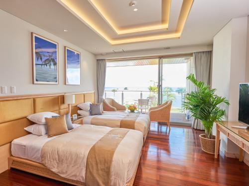 a hotel room with two beds and a television at Ishigaki Resort Hotel in Ishigaki Island