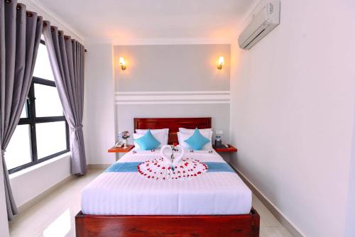 a bedroom with a bed with a cake on it at Sky Palace Boutique Hotel in Battambang