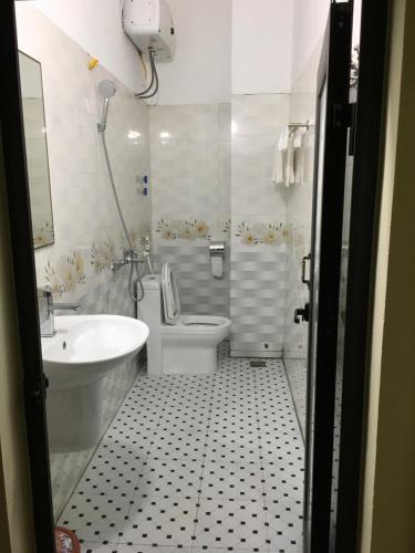 a bathroom with a toilet and a tub and a sink at Nhà nghỉ Tâm Cường in Diện Biên Phủ