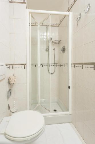 a white bathroom with a shower and a toilet at Millennhotel in Bologna