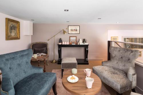 Una sala de estar con dos sofás azules y una mesa. en Logis Maison Vauban - Hotel St Malo, en Saint-Malo