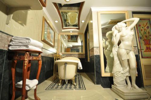 a bathroom with a statue of a woman next to a tub at Shiv Vilas Resort in Jaipur