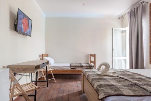 a room with two beds and a table and a desk at Villa Solomare in Zatoka