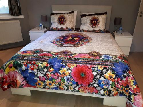 a bed with a colorful quilt on top of it at B&B Uccle in Brussels