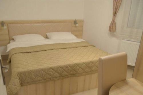 a bedroom with a bed and a chair in it at Holiday Wing Apartments in Jagodina