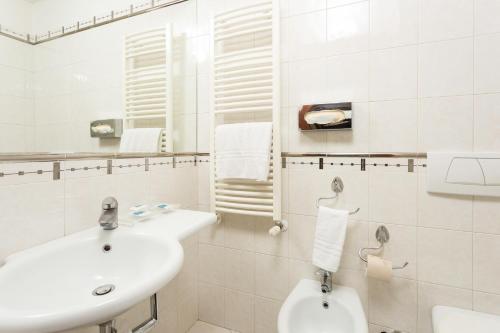 a white bathroom with a sink and a toilet at Millennhotel in Bologna