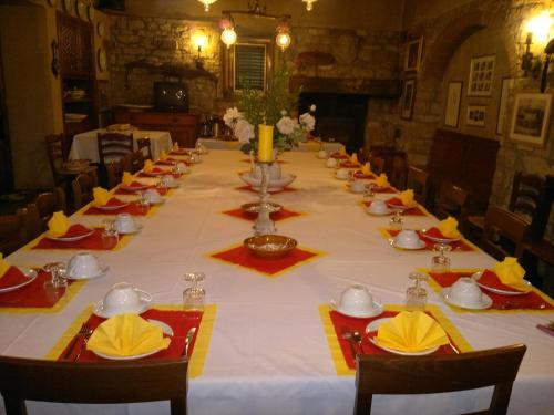 a long table with a white table cloth and yellow napkins at La Fattoressa in Florence