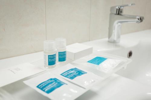 a bathroom sink with two bottles ofodorizers on it at Millennhotel in Bologna