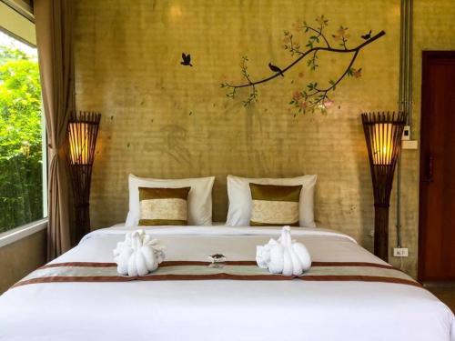 Un pat sau paturi într-o cameră la Villa De Bua Resort Nan